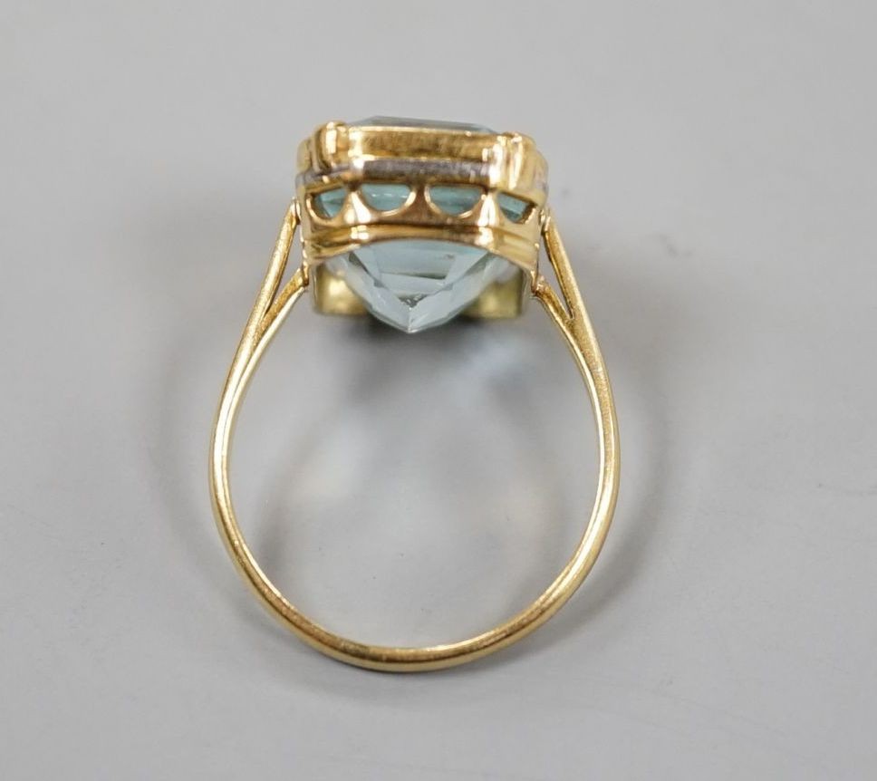 A yellow metal and single stone emerald cut aquamarine set dress ring, size K/L, gross 5.8 grams.